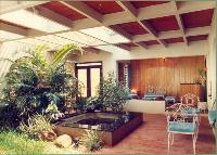 This courtyard was 'created' long after the house was built. The house was in two blocks connected by a corridor that had arches with metal grills and glass windows. The courtyard was created on both sides of this corridor and the far ends enclosed. Concrete pergolas were used to provide security and the balance area was covered with 'hourdi' (hollow clay block) tiles. This prevented the rain beating into the areas closer to the house and also helped regulate the light. Here polycarbonate sheets were not used and rain was allowed to fall into the garden.